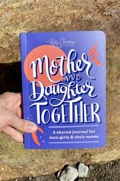 a person holding up a book with the title mother and daughter together