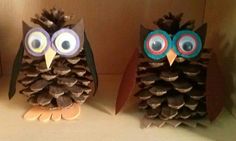 two owls made out of pine cones with googly eyes