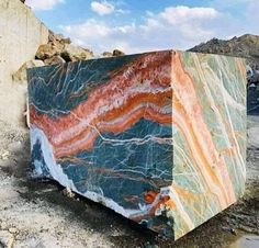 a large marble block sitting on top of a dirt field