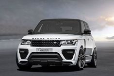 the front end of a white range rover parked in a parking lot with dark clouds behind it