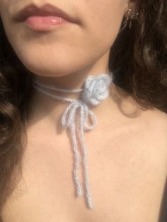 a close up of a woman wearing a white choker with a bow on it