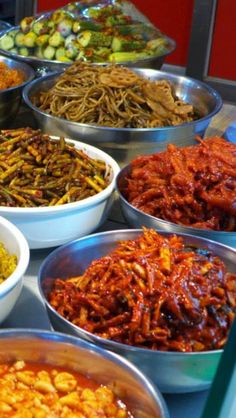 many bowls filled with different types of food