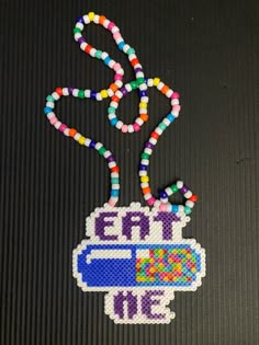 a beaded keychain with the word eat me on it