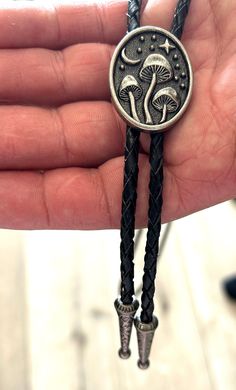 This awesome bolo features a mushroom design. It is solid stainless steel metal, handcrafted by our design team. Quality guaranteed, picture does not do this bolo justice! The piece measures 1 1/2'' x 1 1/4''. It can adjust lengths, 39'' in total length. We have matching belt buckles to pair! Handmade Silver Bolo Tie For Gift, Handmade Silver Bolo Tie As A Gift, Silver Bolo Ties As A Gift, Adjustable Metal Jewelry For Father's Day, Silver Sterling Bolo Tie, Handmade Sterling Silver Bolo Tie As Gift, Adjustable Sterling Silver Bolo Tie, Unique Silver Bolo Tie For Gift, Unique Silver Bolo Tie As A Gift