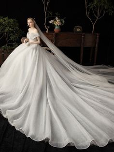 a woman in a white wedding dress standing next to a table