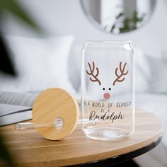 a glass jar with a reindeer face on it next to a wooden paddle and mirror