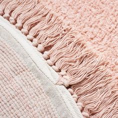 a pink and white rug with fringes on it