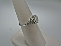 "For Sale: (1) H108 Gorgeous Diamond Ring in 14k White Gold from 1930's PLEASE READ ENTIRE DESCRIPTION BEFORE PURCHASING Please see pictures for more details! This stunning ring features a center 0.06 ct diamond. This is a beautiful filigree mounting down the side. The shank is decorated half way down. The ring is not stamped 14k, but was tested for it. This ring is from the 1930's. A beautiful piece for a any special occasion! What a great Gift! Specifics: *14k White Gold *Center Diamond approx Vintage White Gold Signet Ring With Center Stone, Vintage Oval Signet Ring With Brilliant Cut, Vintage White Gold Signet Ring, Victorian White Gold Jewelry With Vvs Clarity, Vintage Wedding Signet Ring With Round Band, Vintage Vvs Clarity Diamond Ring For Formal Occasions, Estate Style Oval Platinum Rings, Estate Platinum Rings, Estate Rings With Center Stone