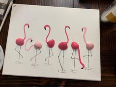 four pink flamingos are lined up on a white canvas