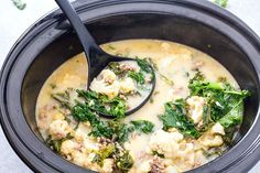 a bowl of soup with broccoli, cauliflower and meat in it