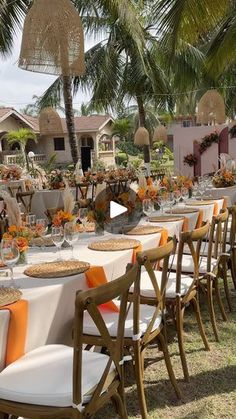 a long table set up for an event with orange and white linens on it