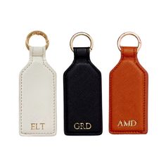 three different colored leather keychais with gold letters on each one and the other side