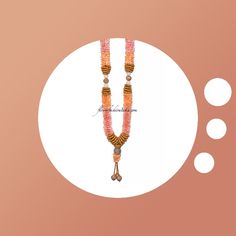 an orange and pink beaded necklace with two white circles around it on a peach background