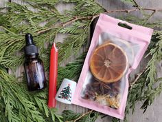 an orange slice in a bag next to some other items on a table with pine branches