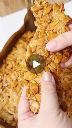 a person holding a piece of food in front of a bowl filled with oatmeal