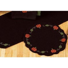 two black place mats with pumpkins on them