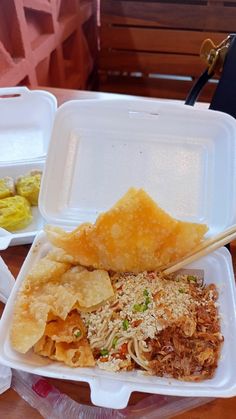 a plastic container filled with food on top of a wooden table