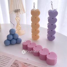 three candles are arranged in the shape of hearts on a table next to a lamp