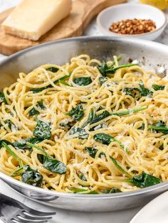 pasta with spinach and parmesan cheese in a skillet on a table