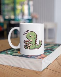 a white coffee mug sitting on top of a table next to a stack of books