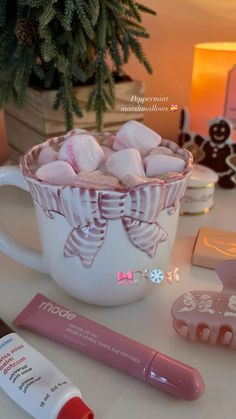 a cup filled with marshmallows sitting on top of a table next to other items