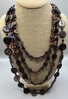 Featuring this lovely, tribal flair, coconut shell and wooden beaded necklace. The necklace is multi strand.   The shortest strand is 20", the longest is 30". The necklace is in very good vintage condition and has a button clasp. Vintage Brown Necklaces For The Beach, Vintage Brown Beaded Necklaces For Beach, Artisan Double Strand Brown Necklace, Traditional Brown Multi-strand Necklaces, Bohemian Brown Double Strand Necklace, Bohemian Brown Long Necklace With Round Beads, Brown Long Necklace For Beach, Adjustable Multi-strand Brown Long Necklace, Adjustable Brown Multi-strand Long Necklace