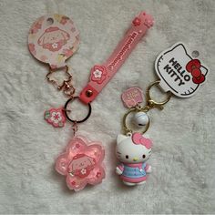 hello kitty keychains and tags are laying on a white surface with a hello kitty tag