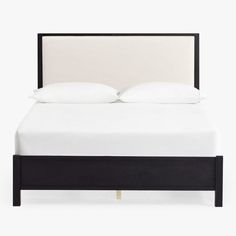 a bed with white pillows and black frame