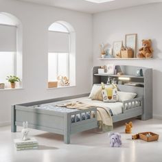 a child's bedroom with white walls and flooring, including a gray bed