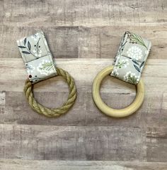 two wooden rings with fabric on them sitting on a wood floor next to each other