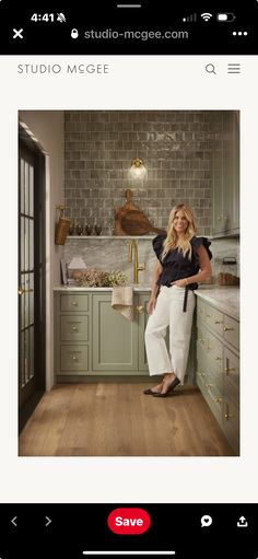 a woman standing in a kitchen next to a window