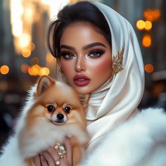 a woman holding a small dog in her arms and wearing a white shawl over her head