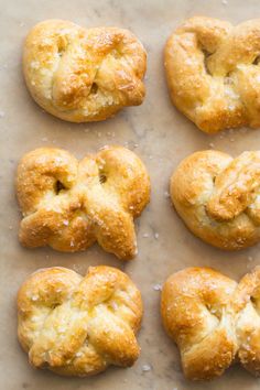 six biscuits are arranged in the shape of an x on a sheet of parchment paper