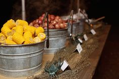 two buckets filled with corn sitting on top of a table