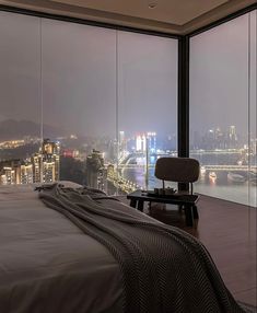 a bedroom with a view of the city at night