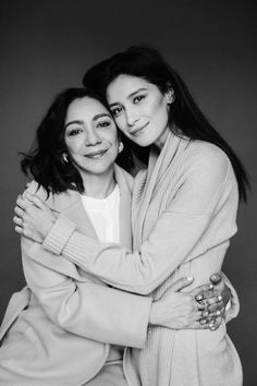 two women hugging each other in black and white