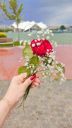 a person holding a bouquet of flowers in their hand