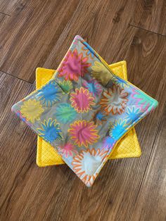 two napkins sitting on top of each other in front of a wooden floor with wood floors