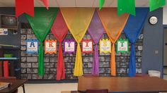 an empty classroom with colorful flags hanging from the wall