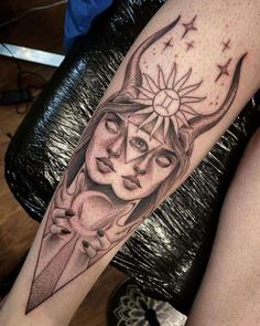 a woman's leg with a tattoo on it that has an image of two faces