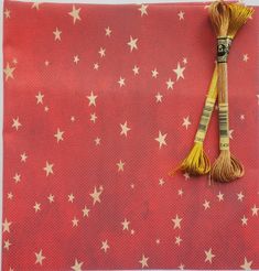 two yellow tassels on top of a red background with white and gold stars