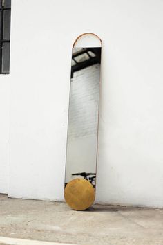 a skateboard sitting on the ground in front of a mirror that is upside down