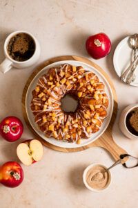 apples, cinnamon rolls and coffee on a table