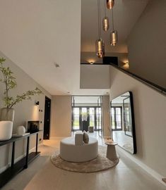 a modern living room with white furniture and large mirrors on the wall, along with an open floor plan