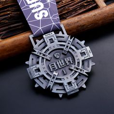 a medal is shown on top of a black surface next to a bamboo stick and some other items