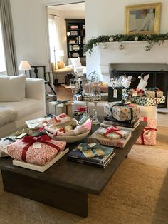 a living room filled with lots of presents on top of a coffee table in front of a fire place