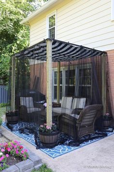 a patio covered with mosquito netting and furniture