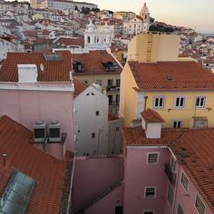 an aerial view of rooftops and buildings in a city with red tile roof tops