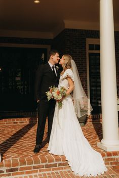 a bride and groom kissing on the steps