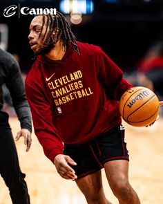 a man with dreadlocks holding a basketball